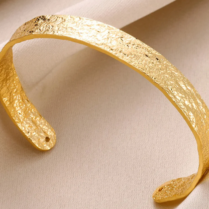 A nossa bracelete Golden&Ripple destaca-se pela sua textura martelada única, que reflete a luz de todos os ângulos como o sol na água.