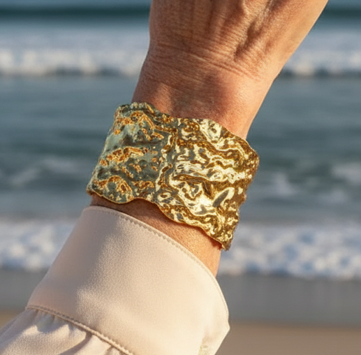 Inspirada no design contemporâneo, esta bracelete larga combina a rigidez do aço com a fluidez visual do ouro líquido. 