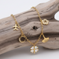 Esta pulseira em aço inoxidável delicada reúne os símbolos universais da proteção e da aventura: o trevo para a fortuna, o avião para as novas experiências e a lua para a intuição.
