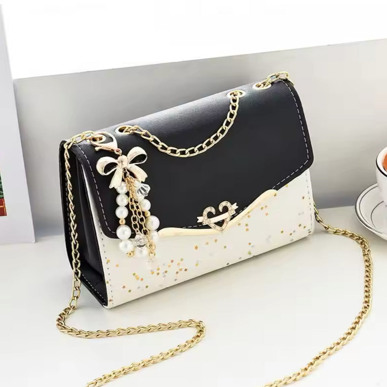 Bolsa de Ombro em Couro Preto com Pingente de Laço Metálico