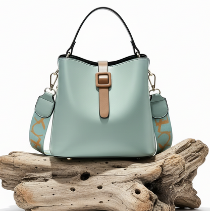 Eleve o seu estilo diário com a Mala Bucket Riviera. Com um design estruturado e minimalista, esta mala destaca-se pela sua cor azul suave e detalhes em tom camelo.