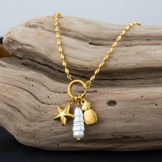 Colar com pendentes de ananás, estrela-do-mar e uma pérola barroca natural, esta peça em aço inoxidável 316L foi desenhada para a mulher que vive intensamente: é totalmente resistente à água, ao suor e a perfumes.
