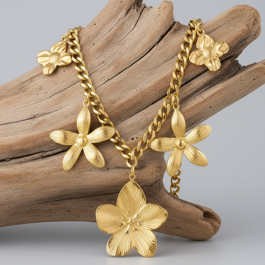 Esta peça "statement" em aço inoxidável apresenta uma corrente de elos robustos adornada com cinco flores esculpidas de diferentes tamanhos, criando um efeito visual dinâmico e luxuoso.